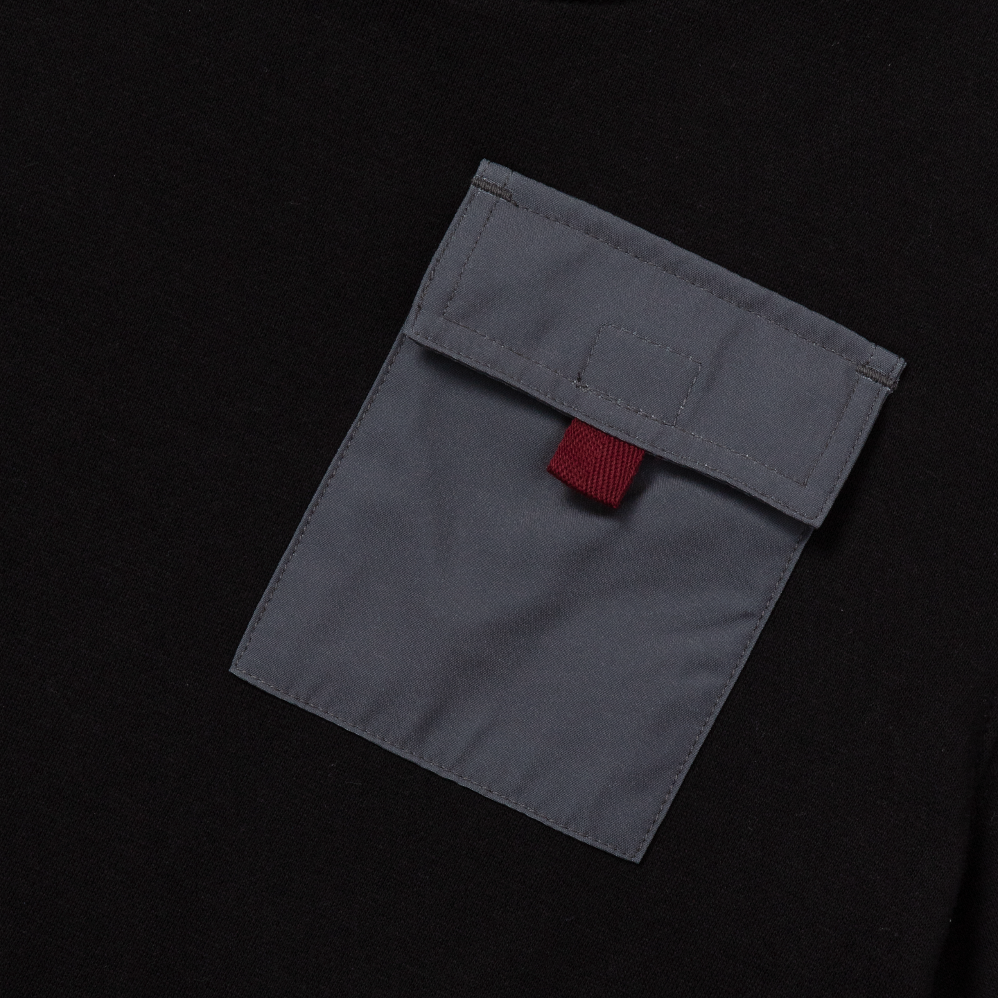 Gray fleece pocket with red label detail on black background.
