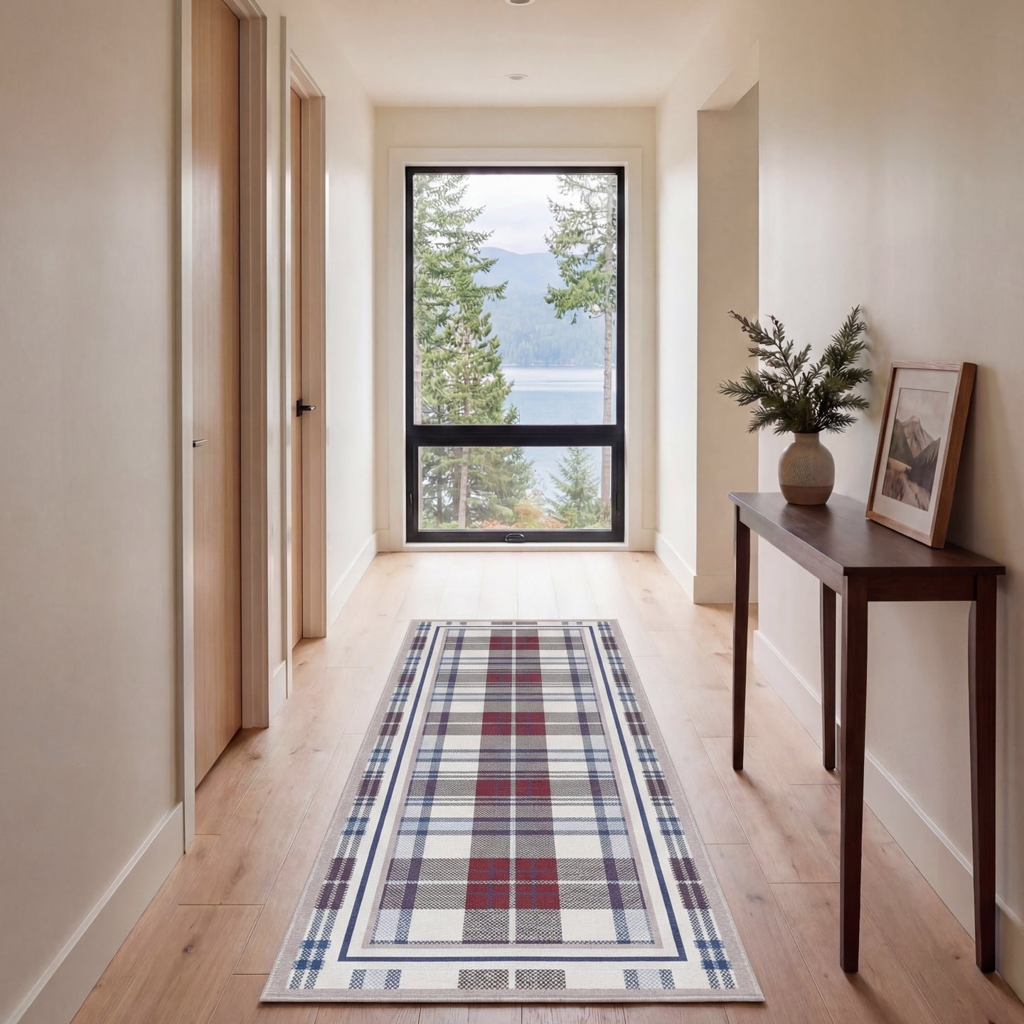 Hallway with a plaid runner rug, wooden console table, and large window overlooking a lake.