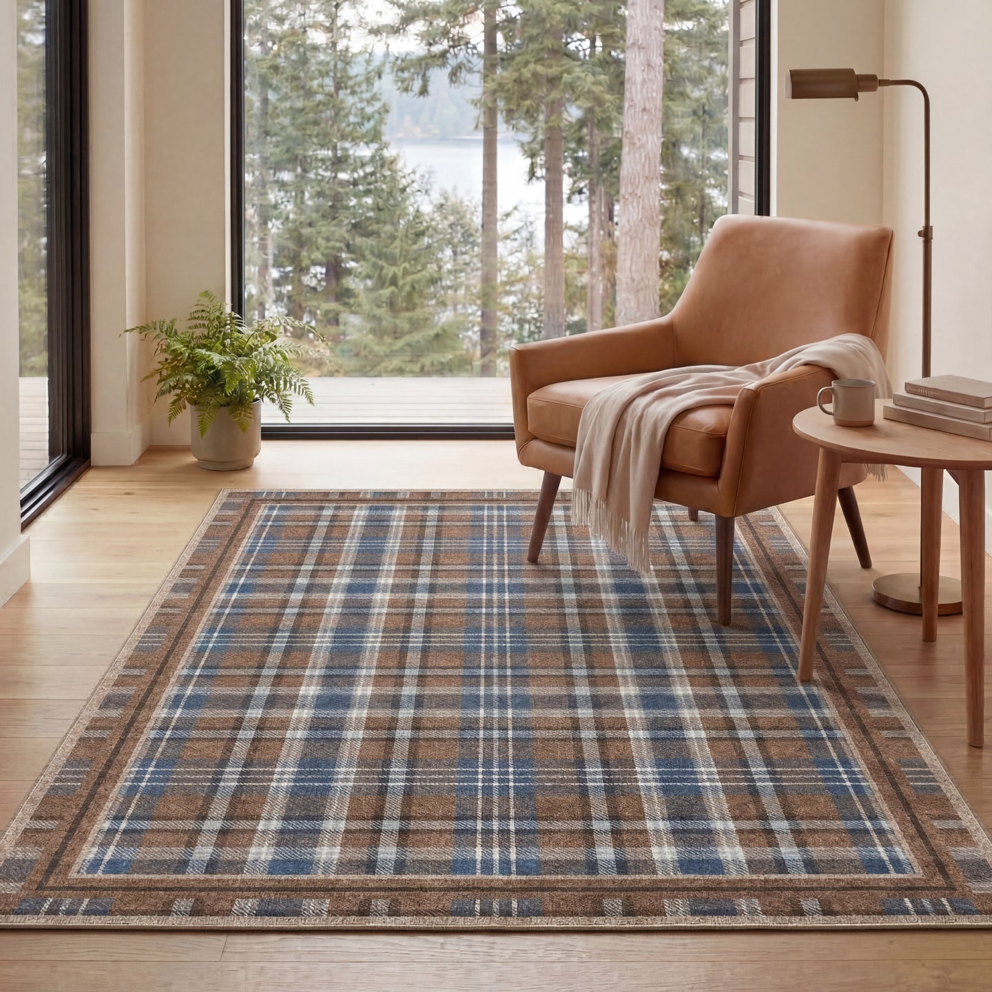 Living room with a plaid rug, brown armchair, and large windows overlooking trees.
