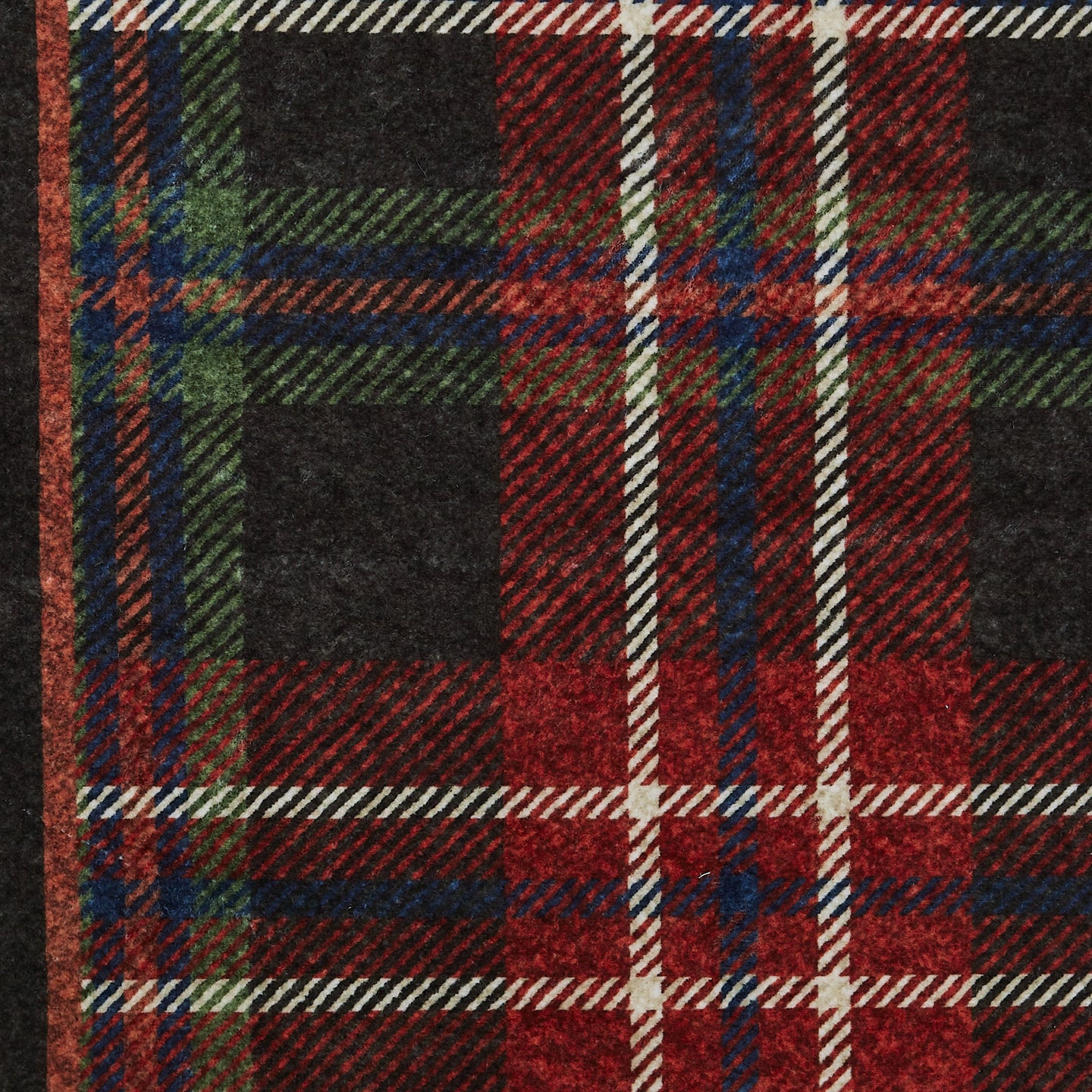 Close-up of a plaid fabric with red, green, and black colors.