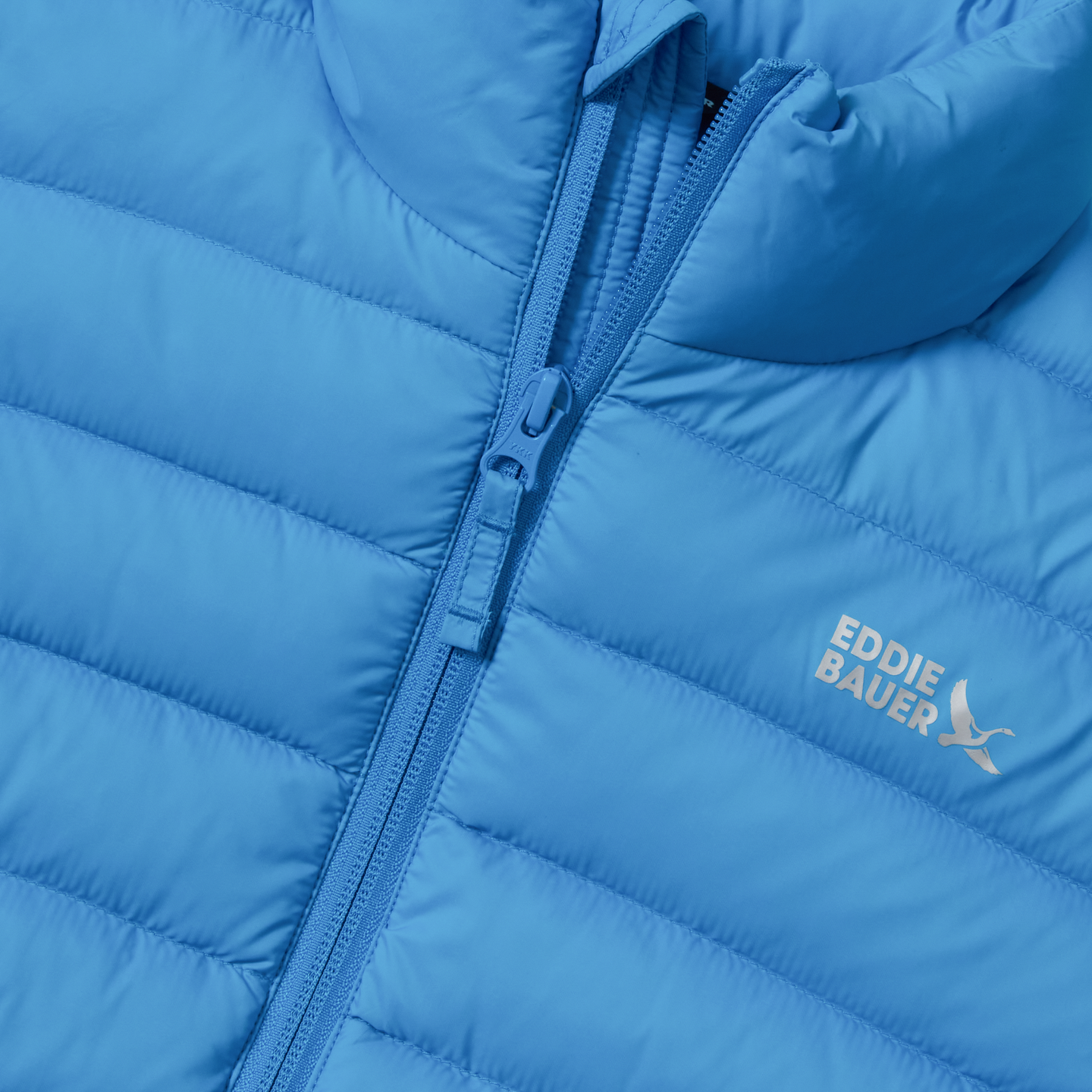 Blue quilted down jacket with full-length zipper and Eddie Bauer logo visible on chest.