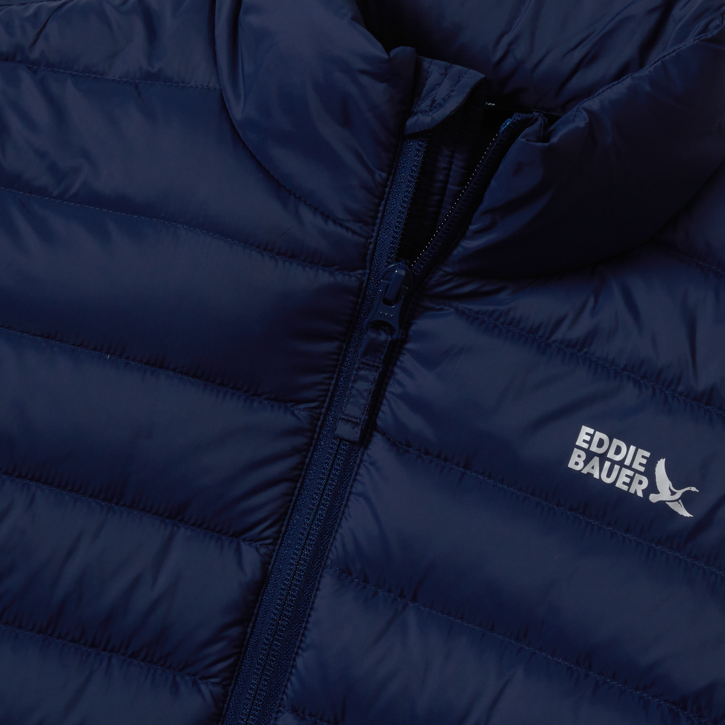 Navy blue quilted down jacket with front zipper and Eddie Bauer logo on chest.